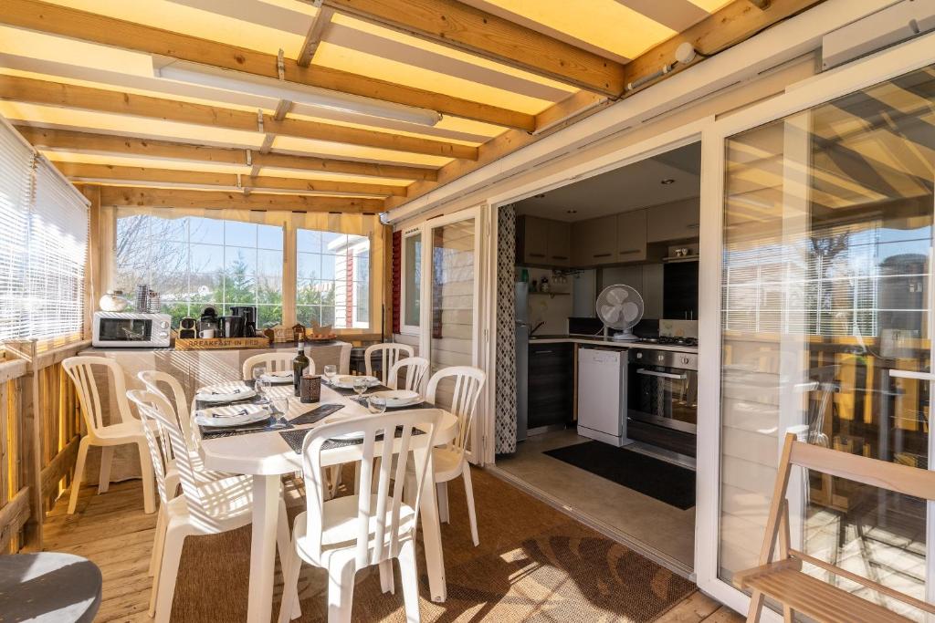 a kitchen and dining room with a table and chairs at Mobil-home in Les Mathes