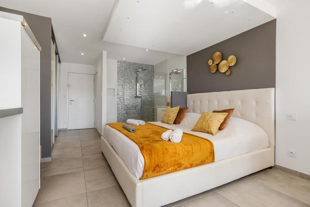 une chambre avec un grand lit blanc avec des serviettes dessus dans l'établissement Village Naturiste R4N - Impérial Héliopolis Luxe, au Cap d'Agde