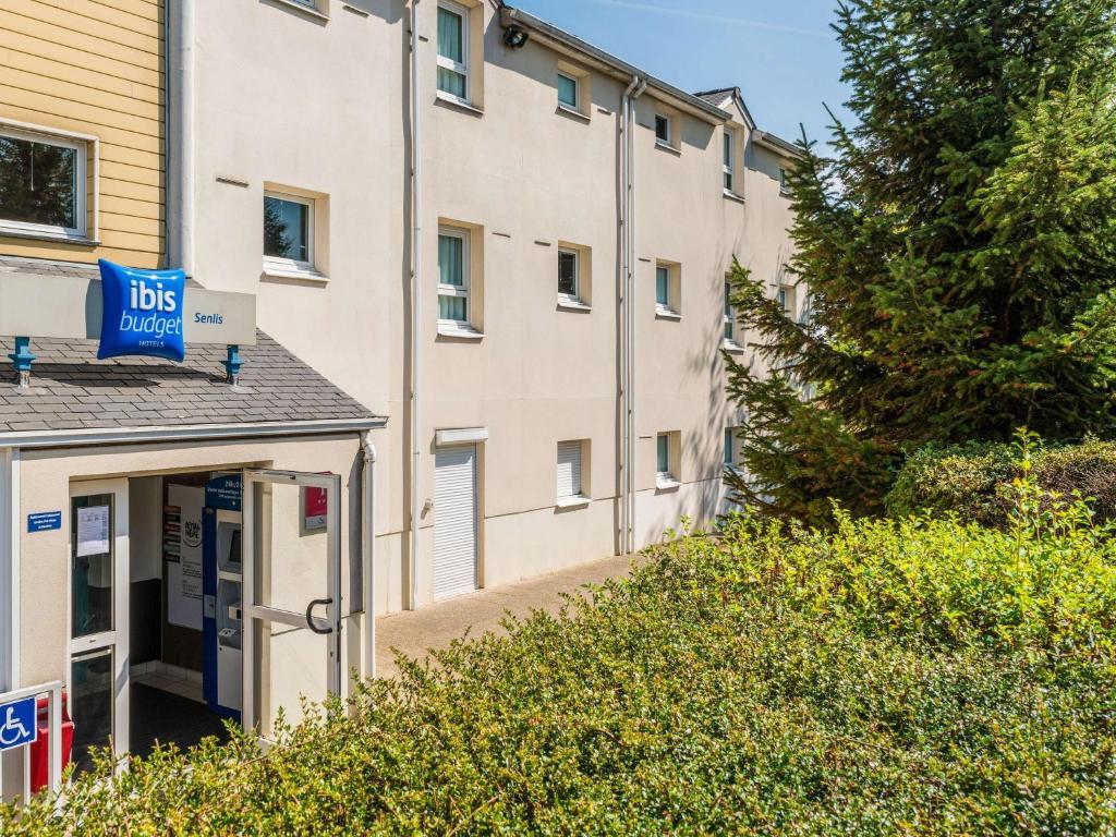 a building with a bus sign on the side of it at ibis budget Senlis in Senlis