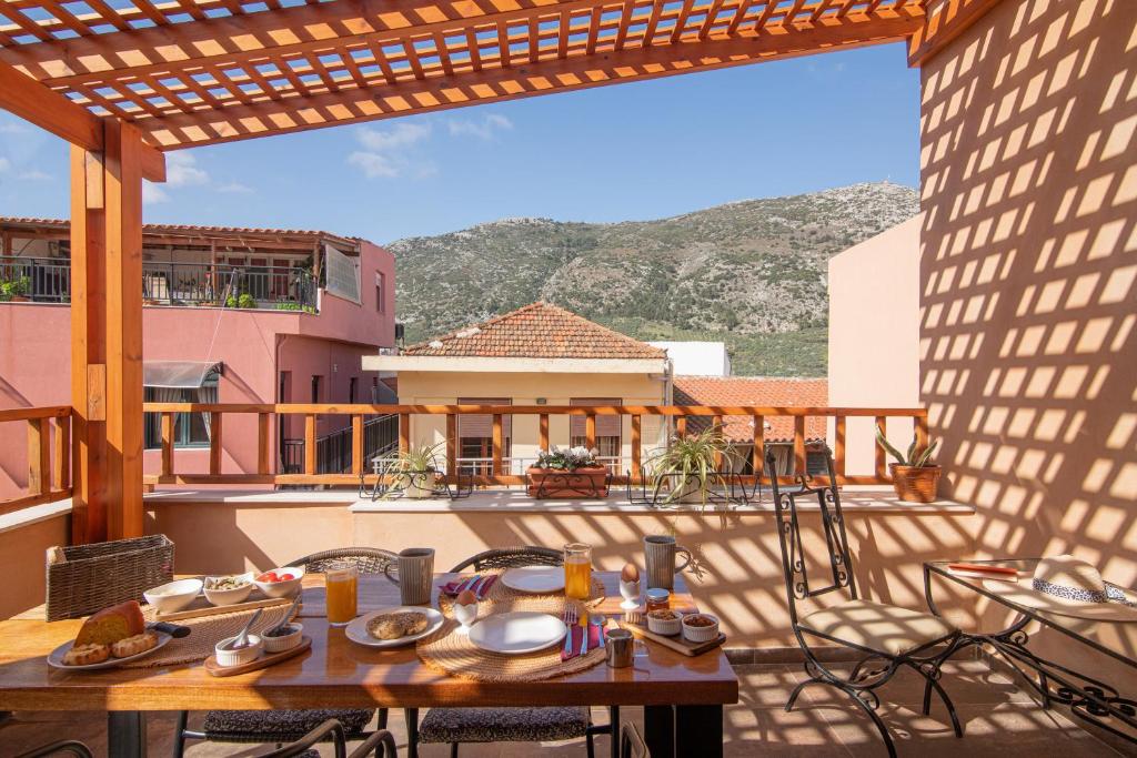 een patio met een tafel en stoelen op een balkon bij CARPE DIEM HOTEL in Archanes