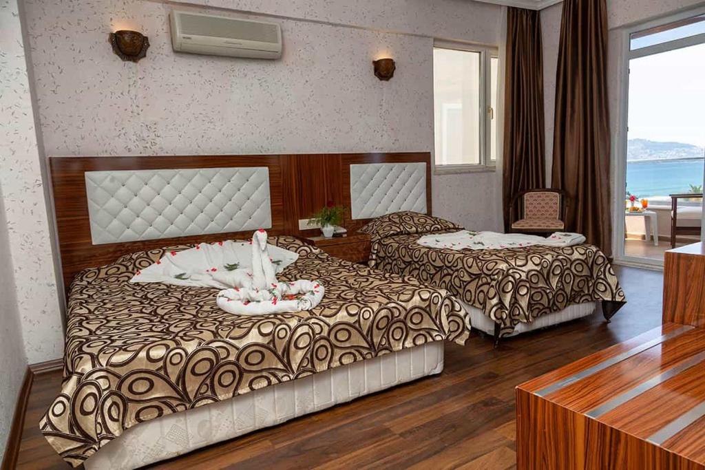 a hotel room with two beds and a table at CLUB BAYAR BEACH HOTEL in Alanya