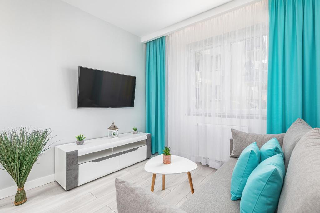 sala de estar con sofá y TV en Modern Apartaments Armii Krajowej in Świnoujście by Rent like home, en Świnoujście