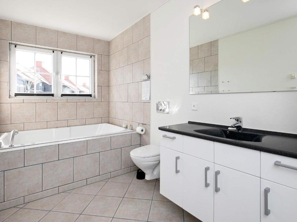 łazienka z wanną, toaletą i umywalką w obiekcie 8 person holiday home on a holiday park in Bogense w mieście Bogense