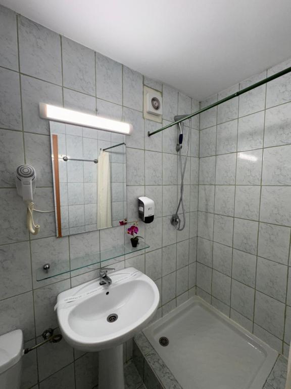 a white bathroom with a sink and a shower at Hotel Venus in Venus