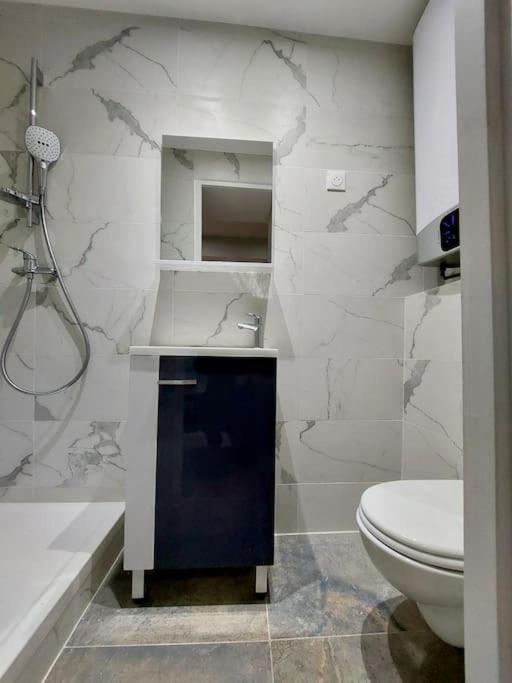 a white bathroom with a toilet and a sink at T2 Atypique en centre-ville in Aix-en-Provence