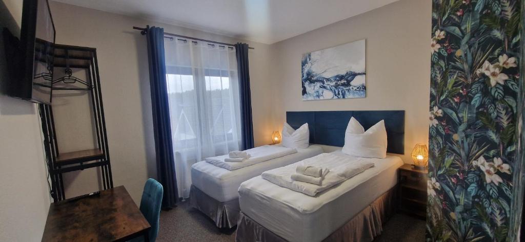 a hotel room with two beds and a window at BusinessHotel Mühlenbeck in Mühlenbeck