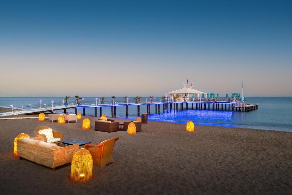 a pier with couches and lamps on the beach at Concorde De Luxe Resort - Prive Ultra All Inclusive in Lara