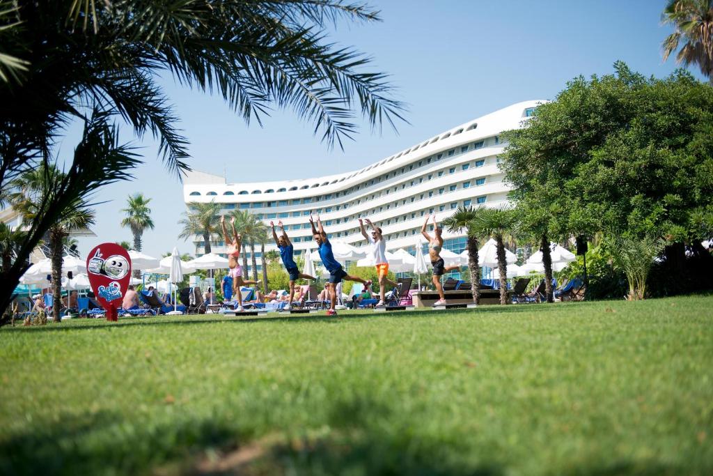 a group of people doing yoga in front of a hotel at Concorde De Luxe Resort - Prive Ultra All Inclusive in Lara