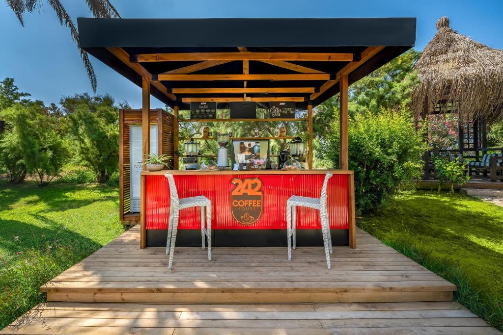 a bar on a wooden deck with two chairs at Concorde De Luxe Resort - Prive Ultra All Inclusive in Lara