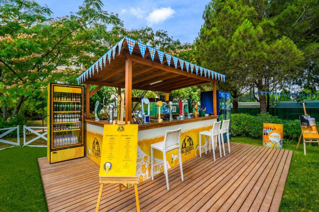 a drink stand on a wooden deck with chairs at Concorde De Luxe Resort - Prive Ultra All Inclusive in Lara