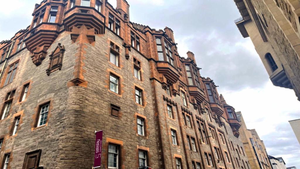 a tall brick building with a clock tower at Safestay Edinburgh Cowgate in Edinburgh