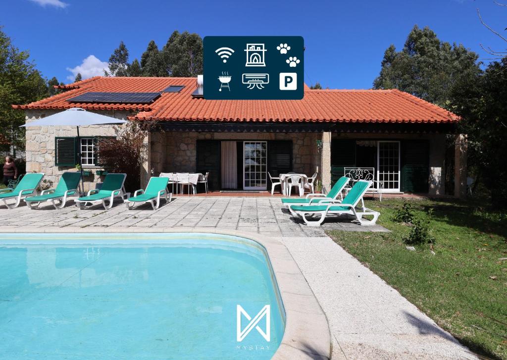 a villa with a swimming pool in front of a house at MyStay - Casa da Carvalha in Arcos de Valdevez