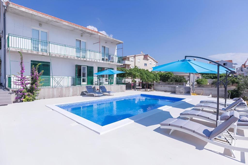 a swimming pool with chairs and an umbrella at NEW! Apartments with shared pool, Vodice in Vodice