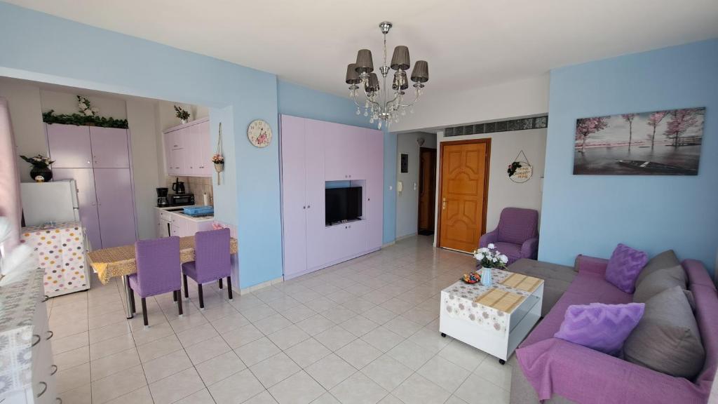 salon z fioletową kanapą i stołem w obiekcie Mary's Apartment w mieście Kos