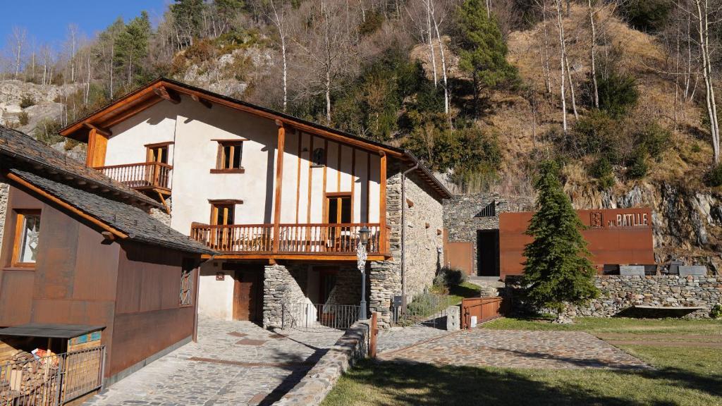 ein Haus mit einem Balkon an der Seite in der Unterkunft Cal Batlle Casa Rural in La Cortinada