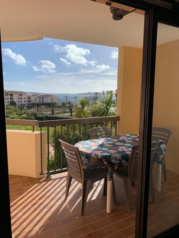 een balkon met een tafel en stoelen en uitzicht bij Appartement Domaine de la Coudouliere + piscine (mai à octobre) in Six-Fours-les-Plages