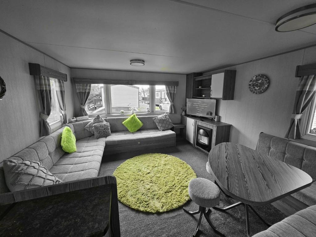 ein Wohnzimmer mit einem Sofa und einem Tisch in der Unterkunft Lovely 3 Bed Caravan near to beach 5 star Reviews in Cleethorpes