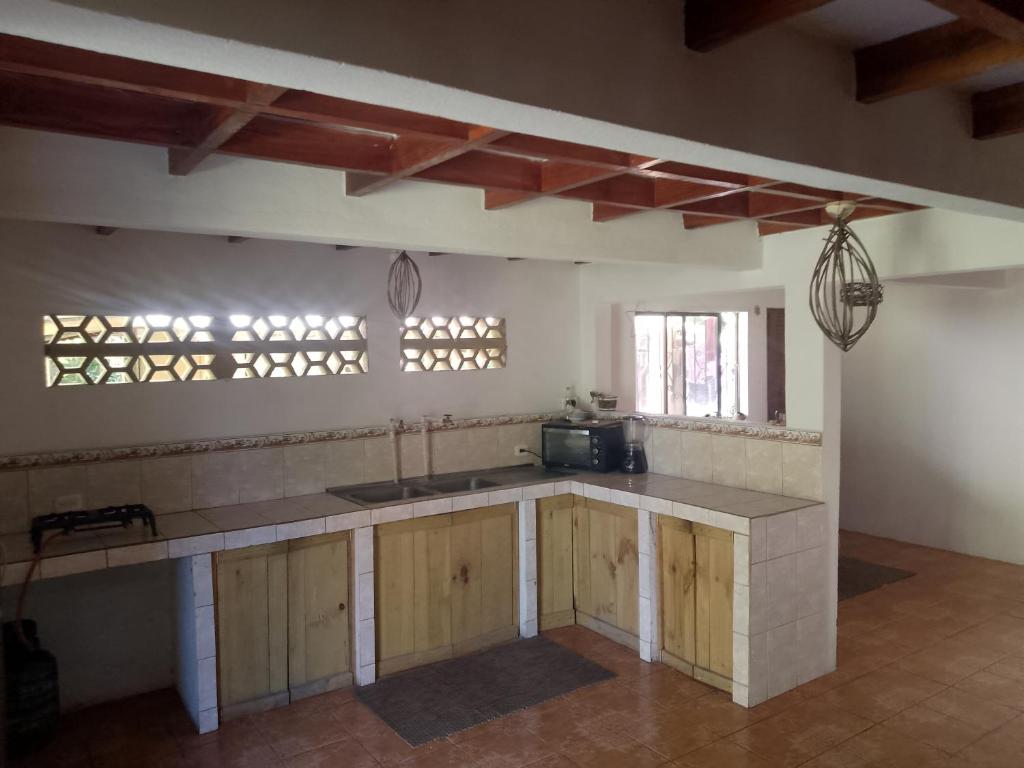 cocina con armarios de madera y encimera en Casa Qi Boho B&B, en Cabuya