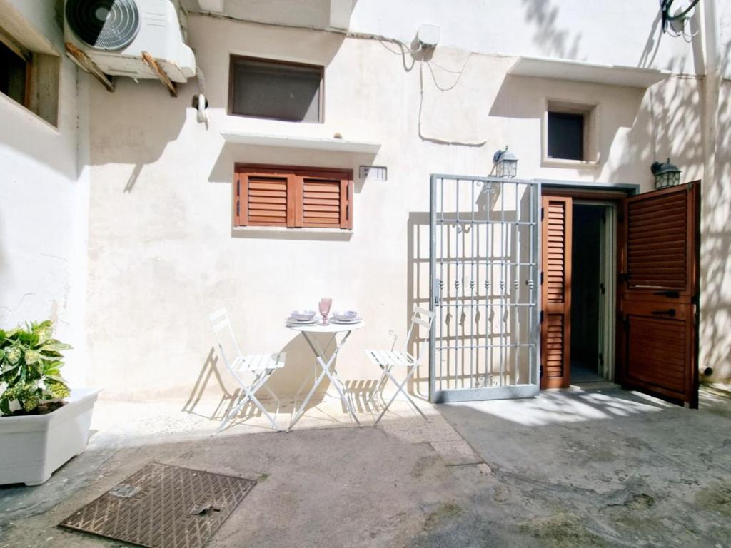 un patio con mesa y sillas frente a un edificio en GALLIPOLI CENTRO STORICO en Gallipoli
