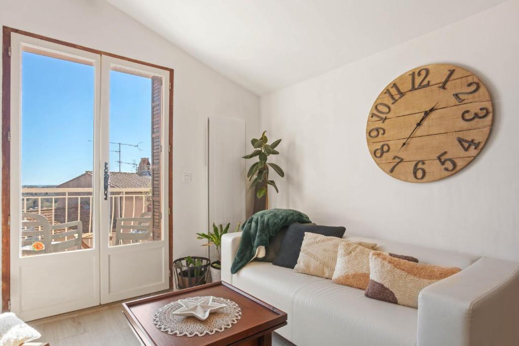 - un salon avec un canapé blanc et un grand réveil dans l'établissement Appartement de ville Fréjus, à Fréjus