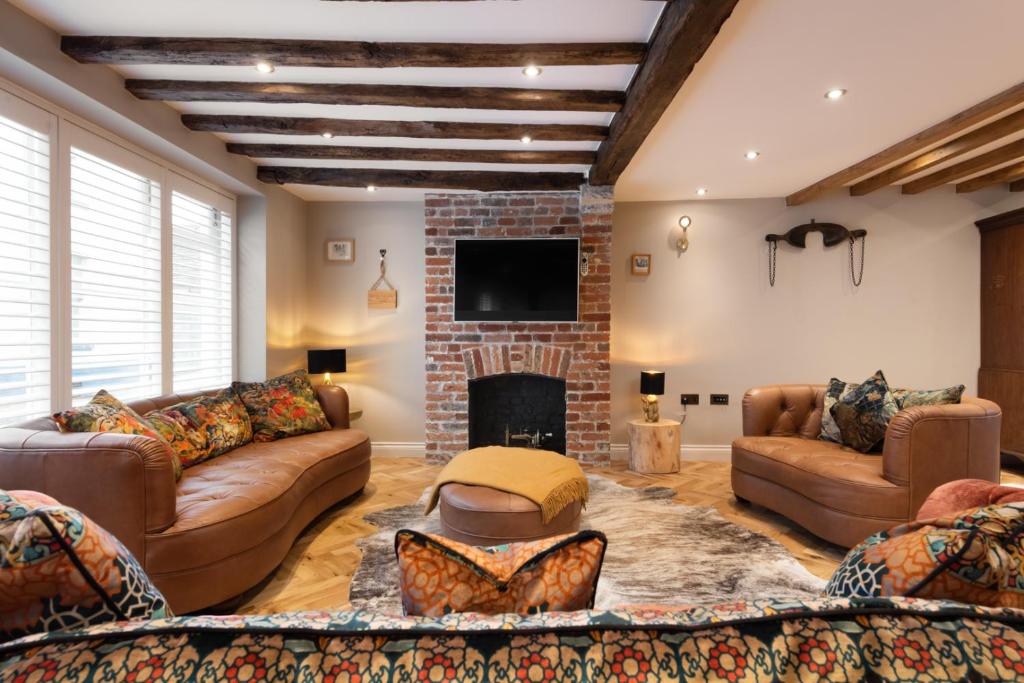uma sala de estar com sofás e uma lareira em Crippens, A historic 5 star Home Hotel Free Parking EV, inglenook fireplace em Canterbury