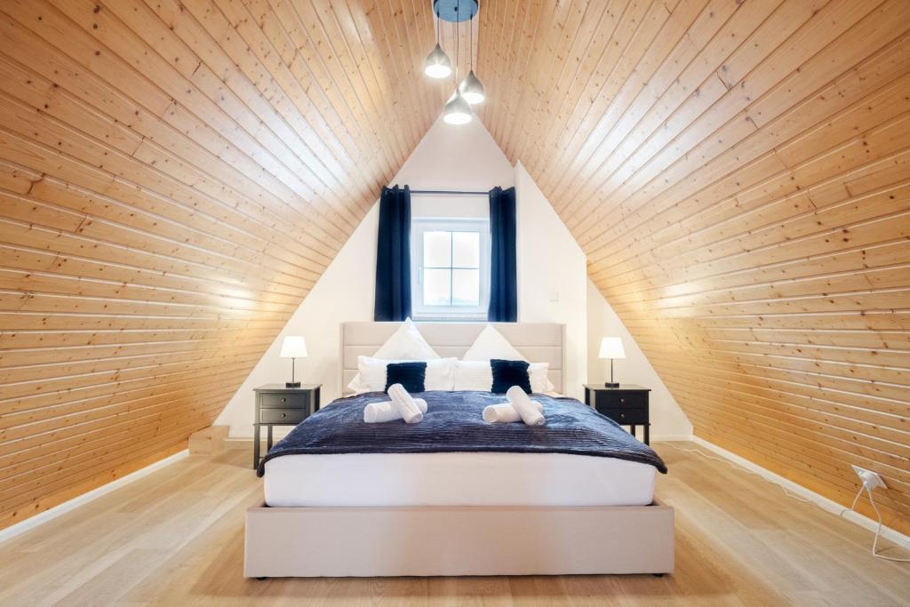 1 dormitorio con 1 cama grande y techo de madera en NEU Deluxe Suite Münsterblick, Maisonette, Kingsize Bett, Küche, Netflix, Aussicht, E-Kamin, en Bad Säckingen