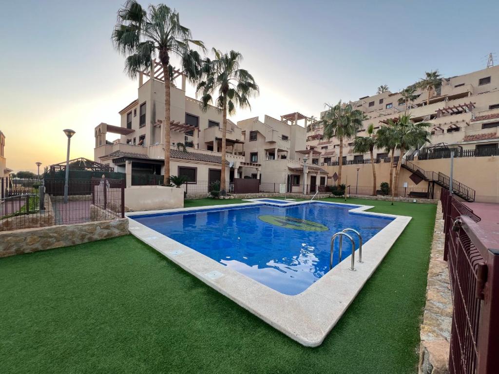 uma grande piscina em frente a um edifício em Apartamento entero con terraza y piscina em Águilas