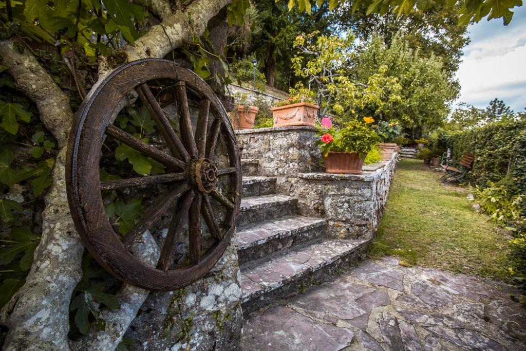 グレーヴェ・イン・キアンティにあるAuthentic Chianti StoneHouse with Garden&Terraceの石壁に寄りかかる古木製車輪