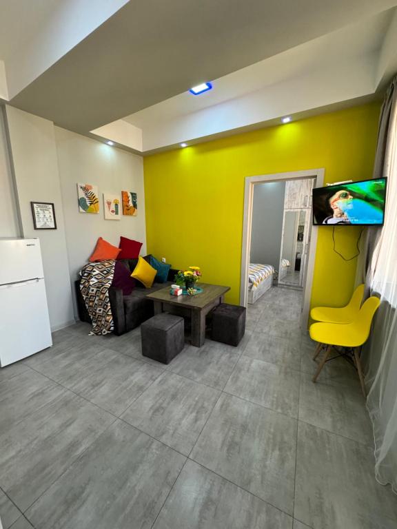 ein Wohnzimmer mit einem Sofa und einem TV in der Unterkunft Comfy Apartment with a Spacious Balcony Self Check In in Yerevan