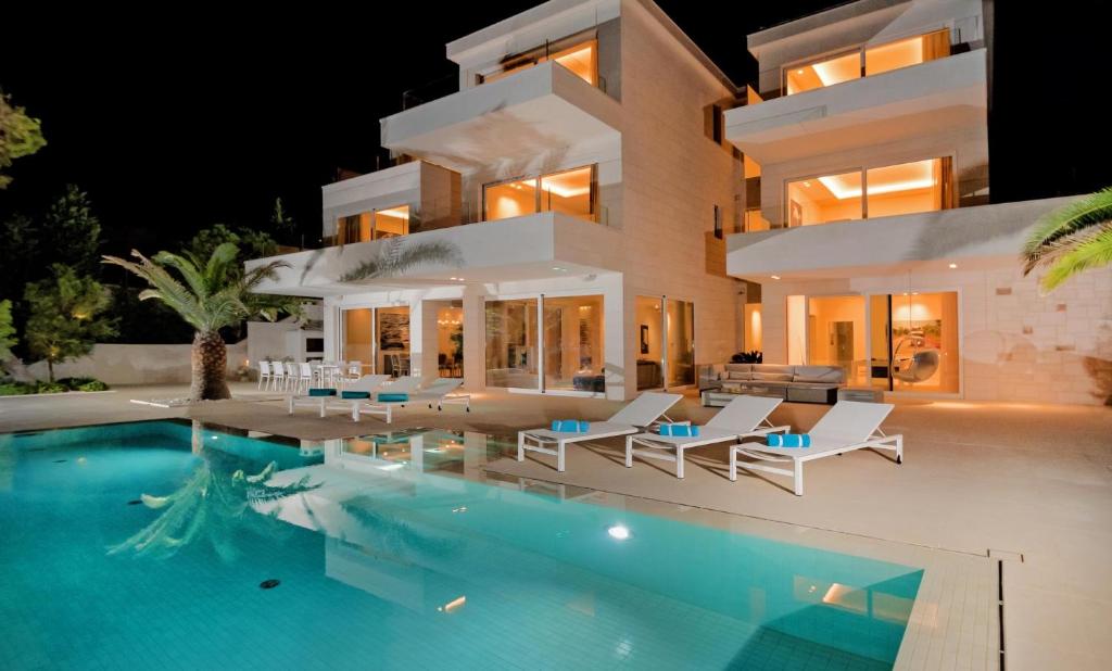 a villa with a swimming pool at night at Villa Brac Neptuno - 6 Bedroom Luxury Villa - Sauna - Gym - Sea Views in Selca