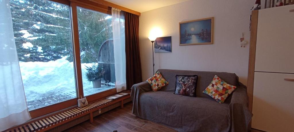 uma sala de estar com um sofá e uma grande janela em Ski apartment Sellette San Sicario Alto em San Sicario