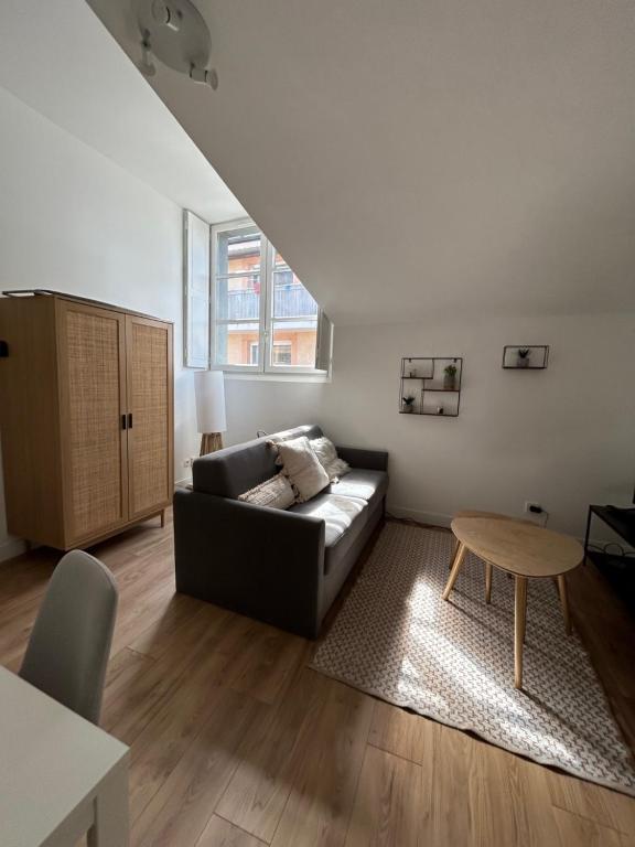 un salon avec un canapé noir et une table dans l'établissement L'embarcadère Toulousain - T1 - Gare - centre ville, à Toulouse