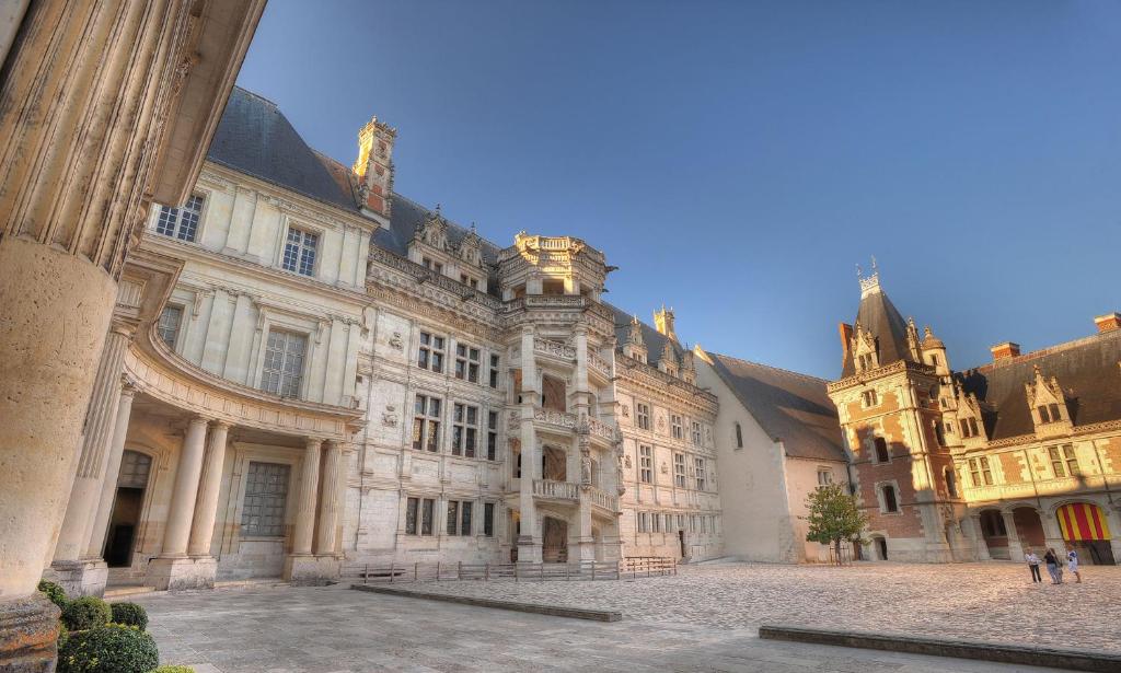 a large building in a courtyard with people standing outside at Perle de la Loire in Blois
