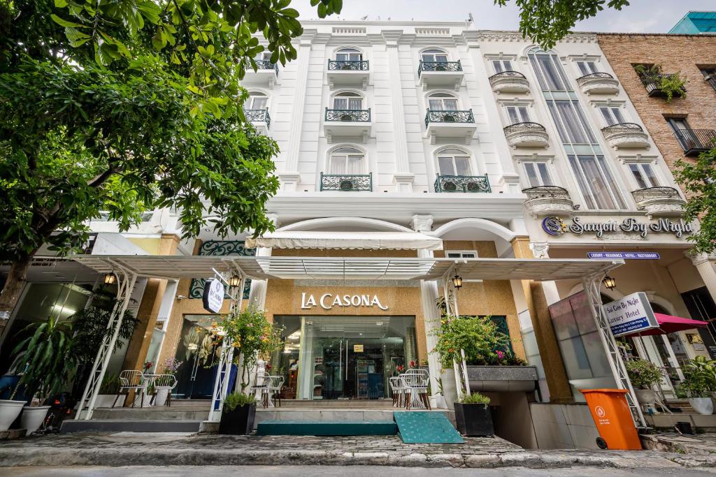 een groot wit gebouw met een winkel ervoor bij La Casona Boutique Hotel in Ho Chi Minh-stad