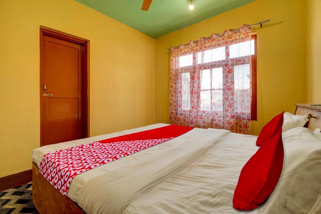 Schlafzimmer mit einem großen Bett mit roter Krawatte in der Unterkunft OYO Flagship Wooden Cave By M2 in Srinagar