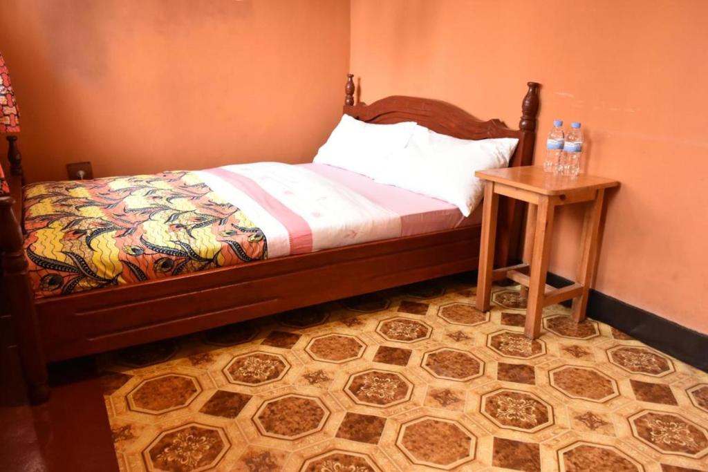 1 dormitorio con 1 cama y mesa auxiliar en Room in BB - Amahoro Guest House - Double Room with Private Shower Room en Ruhengeri