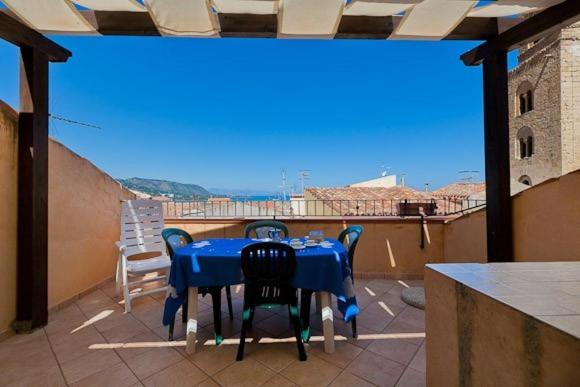 una mesa azul y sillas en el balcón en Terrazza delle mura, en Cefalú