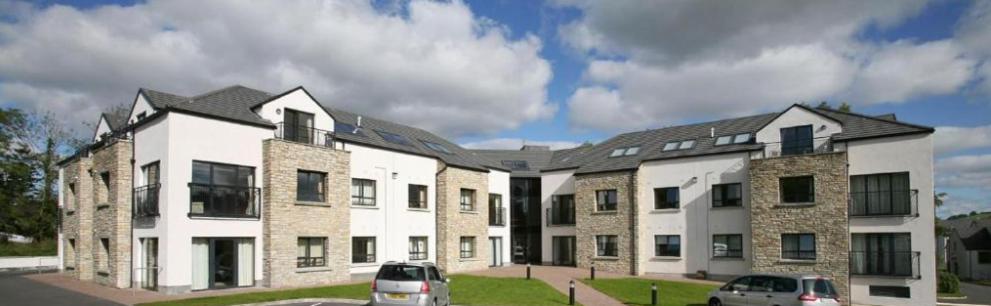 a large building with cars parked in front of it at No.3 Mill Park a luxury self-catering apartment in Donegal