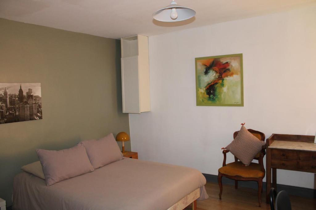 a bedroom with a bed and a table and a desk at Agréable appartement P2 Centre ville au calme. in Nîmes