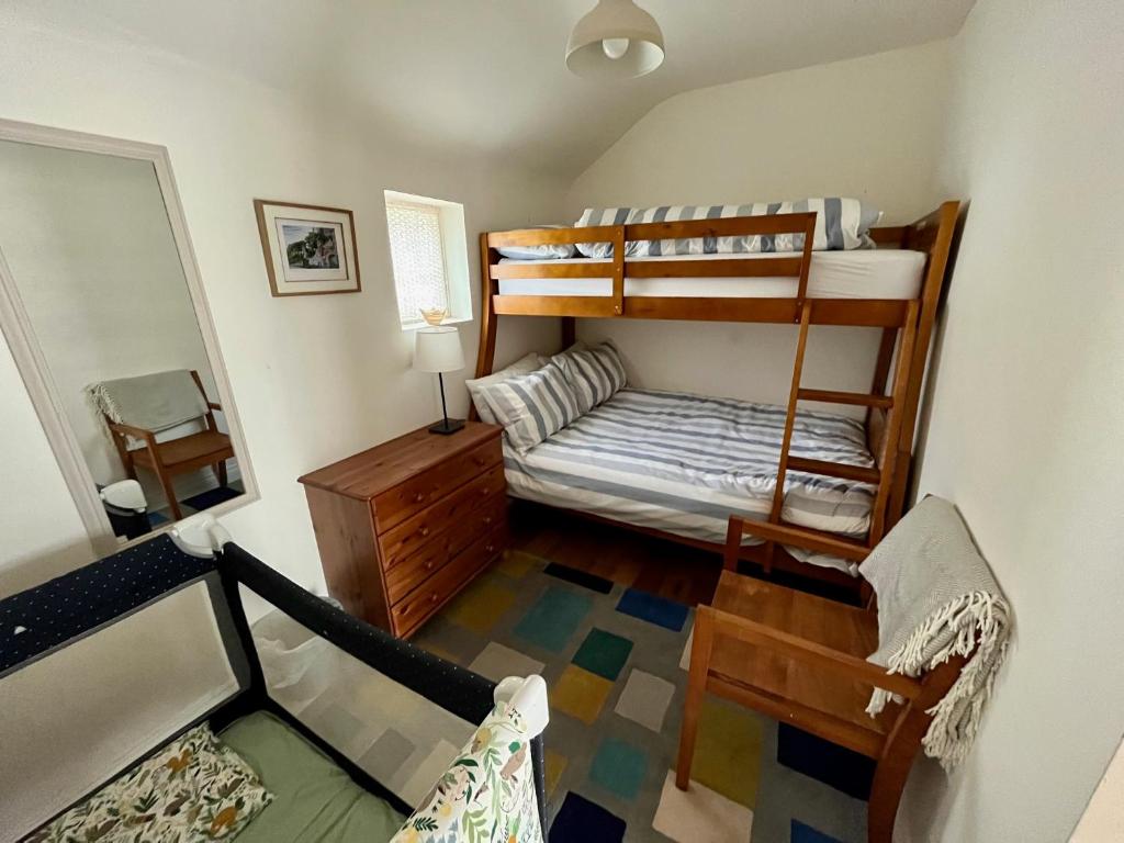 a small room with bunk beds and a mirror at Teal Cottage, Killlyleagh in Killyleagh