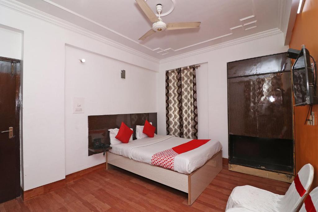 um quarto com uma cama com almofadas vermelhas e uma televisão em OYO Flagship Hotel Novelty Pride em Bankipur