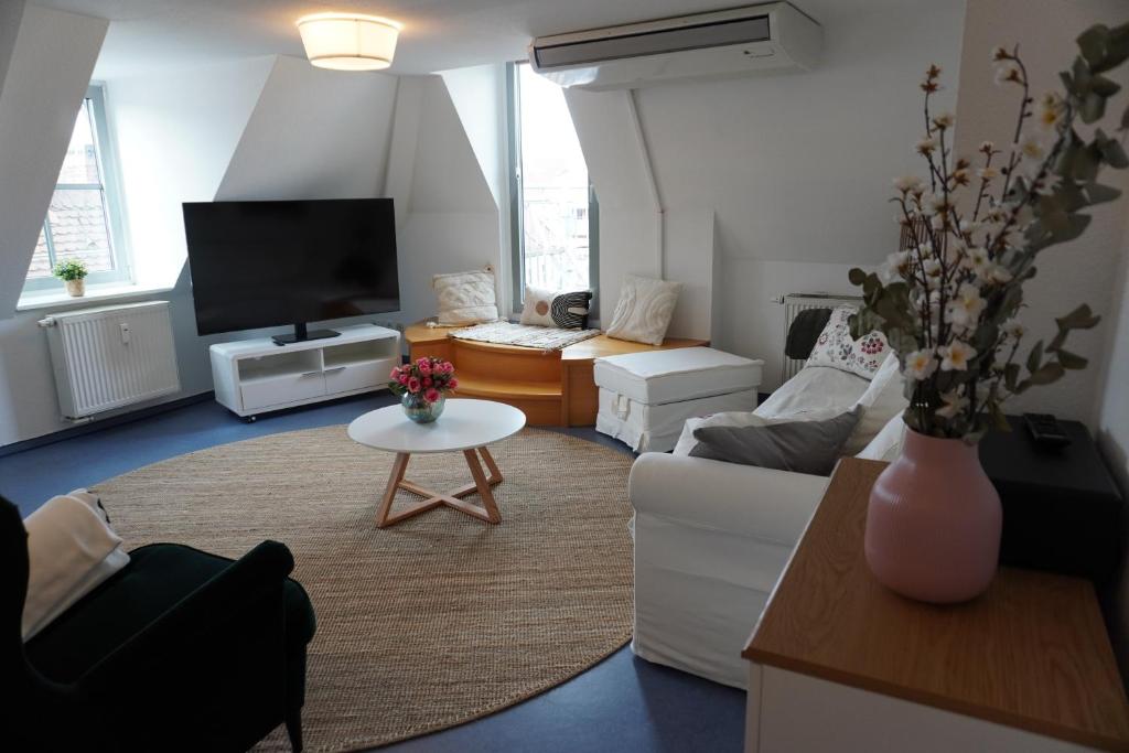 a living room with a white couch and a tv at City Apartement im Herzen der Stadt in Würzburg