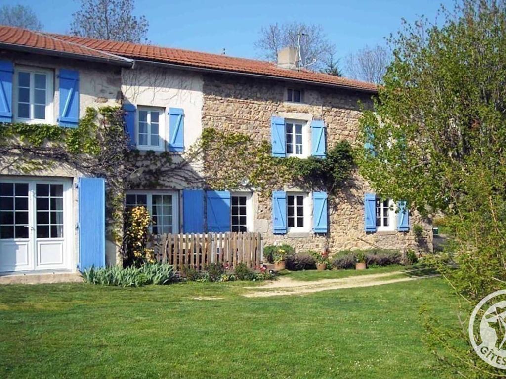 une maison en briques avec des volets bleus et une cour dans l'établissement Gîte Saint-Alban-les-Eaux, 7 pièces, 10 personnes - FR-1-496-95, à Saint-Alban-les-Eaux