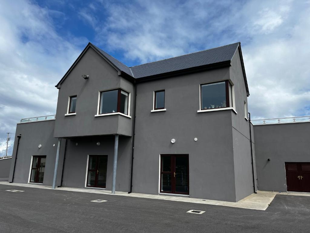 a black building with windows on the side of it at Achill Surf Lodge in Mayo