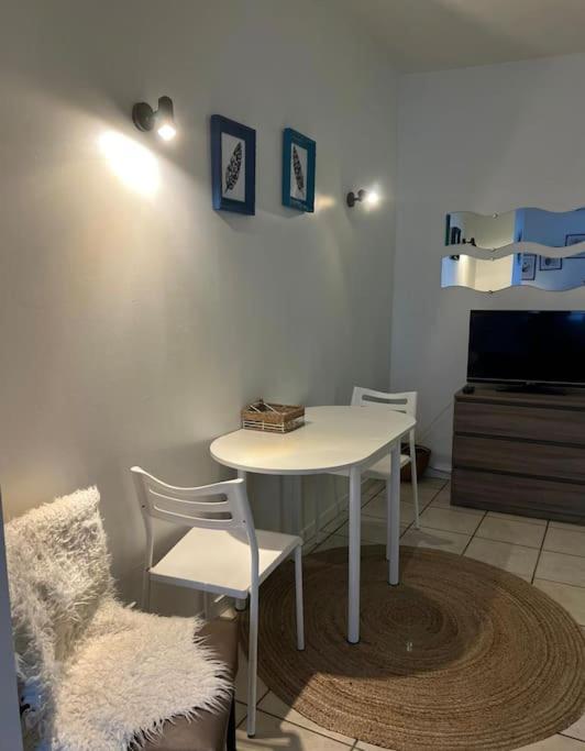 a room with a table and chairs and a tv at Studio Cosy Bord De Loire in Orléans