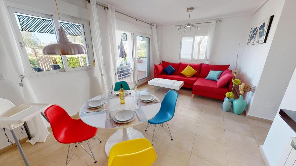 sala de estar con mesa y sofá rojo en Casa Fresa, A Simply Spanish Rentals Property, en Murcia