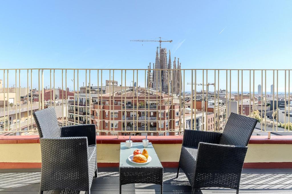 a table and chairs on a balcony with a view of a city at AB Sagrada Família Comfort in Barcelona