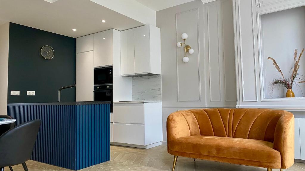 a kitchen with a orange chair in a room at Appartement Apollinaire au cœur de Lorient in Lorient