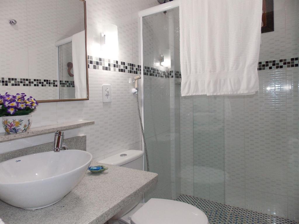 a bathroom with a shower and a sink and a toilet at Portal dos Borbas in Abraão