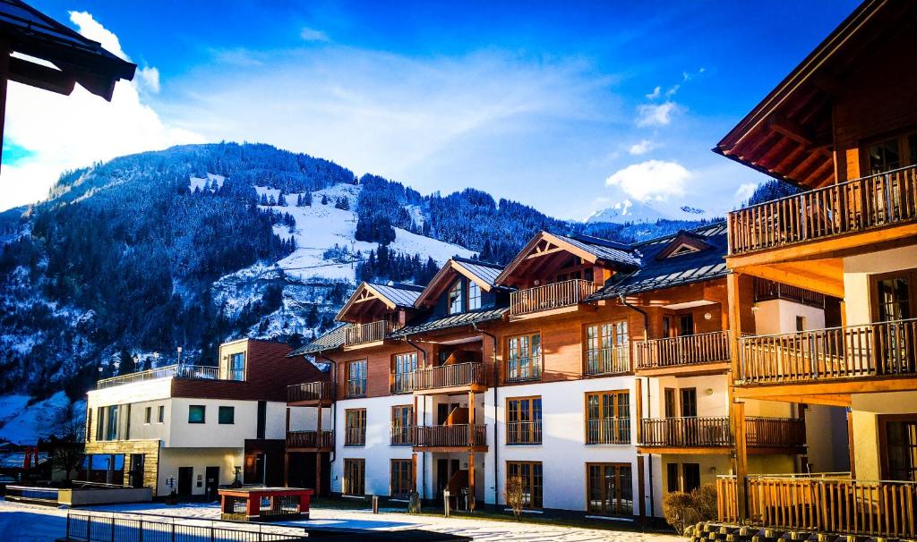 a group of buildings with mountains in the background at Modern Mountain Penthouse - an der Skipiste in Rauris